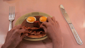 Gif preparándo el desayuno, huevos fritos con bacon y en forma de cara